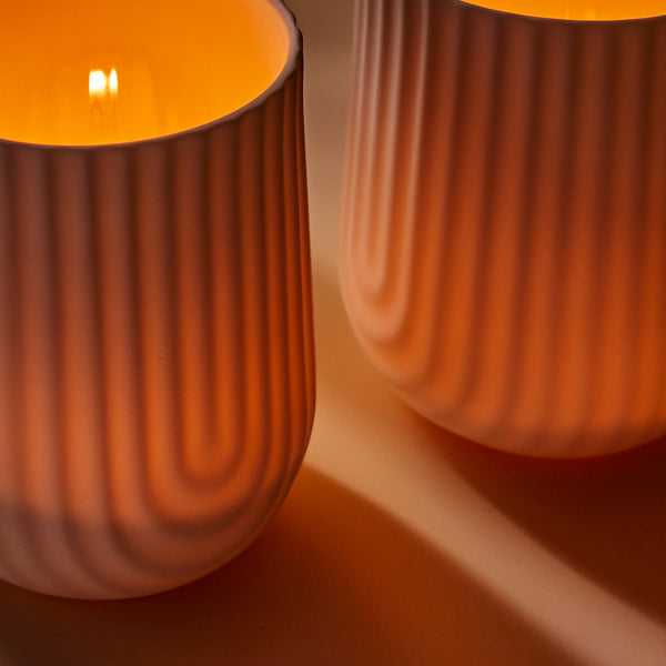 Load image into Gallery viewer, Demonstrating the glow of the beautifully designed white porcelain candle vessel