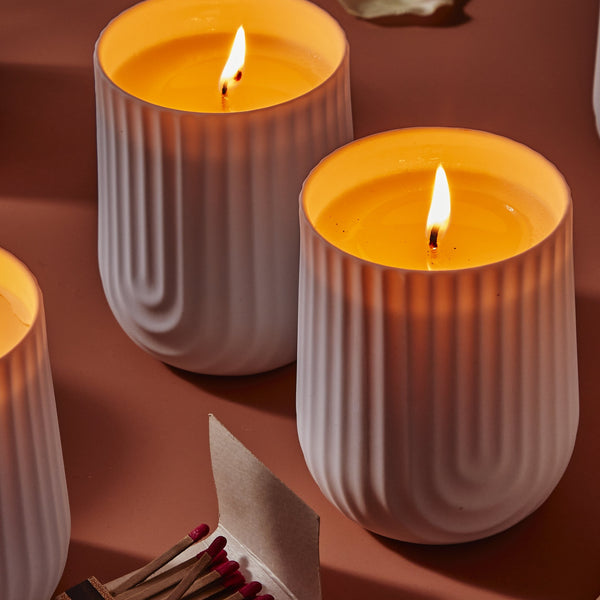 Load image into Gallery viewer, Beautifully designed white porcelain candle vessel demonstrating the incredible warm glow.