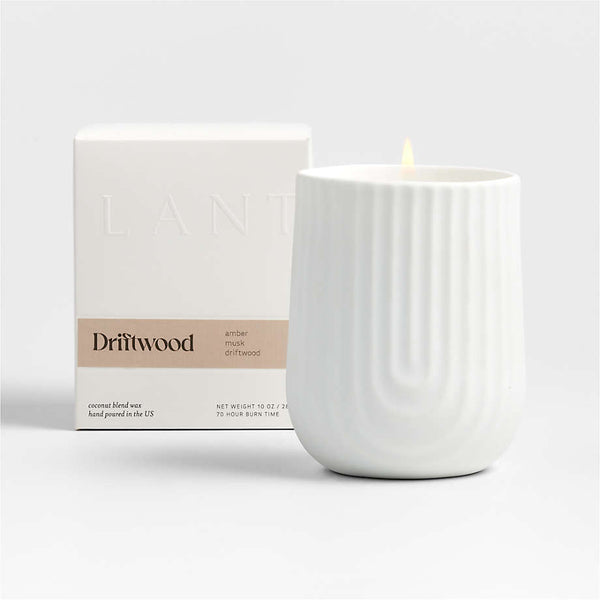 Load image into Gallery viewer, A white porcelain candle holder with vertical ridges is lit from within, showcasing a warm glow. Next to it is its packaging box with the brand name 'Lanterne' visible on it.